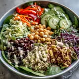 2. Vibrant Rainbow Salad Bowl with cherry tomatoes, purple cabbage, and protein-rich beans, perfect for a healthy meal.  