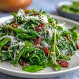 Fresh arugula salad with lemon vinaigrette and shaved Parmesan, a light and tangy dish perfect for a healthy lunch or dinner side.