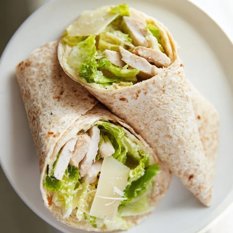 Freshly assembled Chicken Caesar Wrap, showcasing tender chicken and crisp romaine lettuce, ready to eat.
