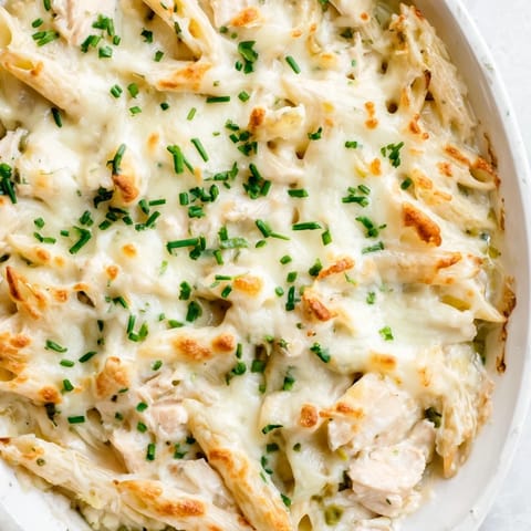 Golden bubbly mozzarella tops a creamy chicken ranch pasta bake in a 9x13 dish, fresh from the oven.