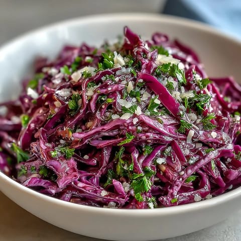 Freshly shredded purple cabbage, julienned green apple, and savory Parmesan shavings create a colorful, crunchy vegetarian side dish for any meal.