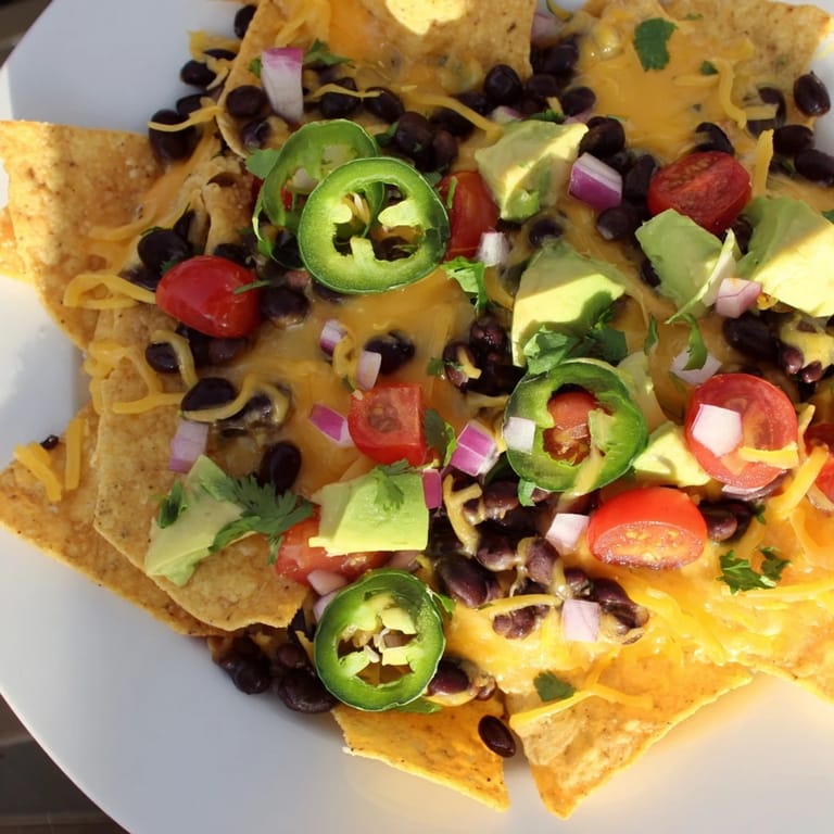 A sizzling platter of loaded nachos, perfect game-day appetizer with fresh toppings.