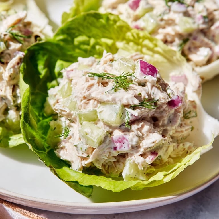Crisp butter lettuce cups cradling savory Dill Pickle Chicken Salad Lettuce Cups, garnished with bright green dill.